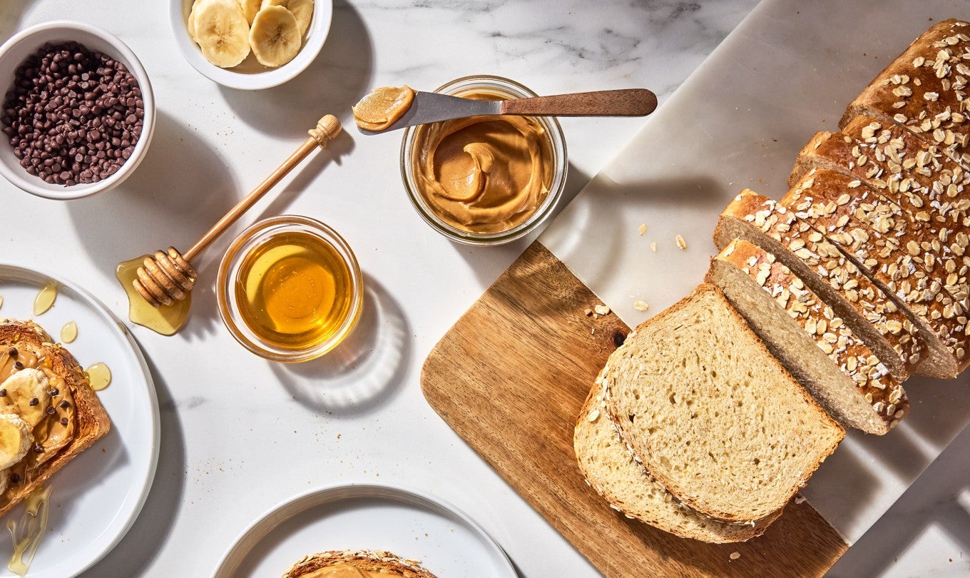 Back-of-the-Bag Oatmeal Bread sliced and served with peanut butter, bananas, and honey