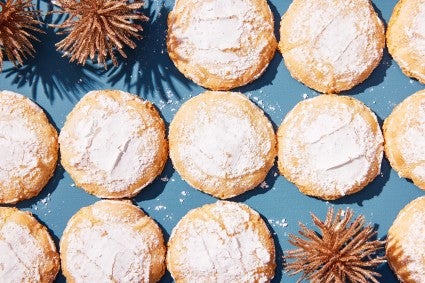 Baked cookies laying in rows on a blue background.