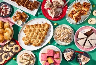 Multiple different holiday recipes plated on a green background