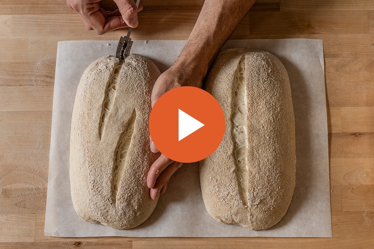 Hands scoring a batard, with a video play button graphic overlaid